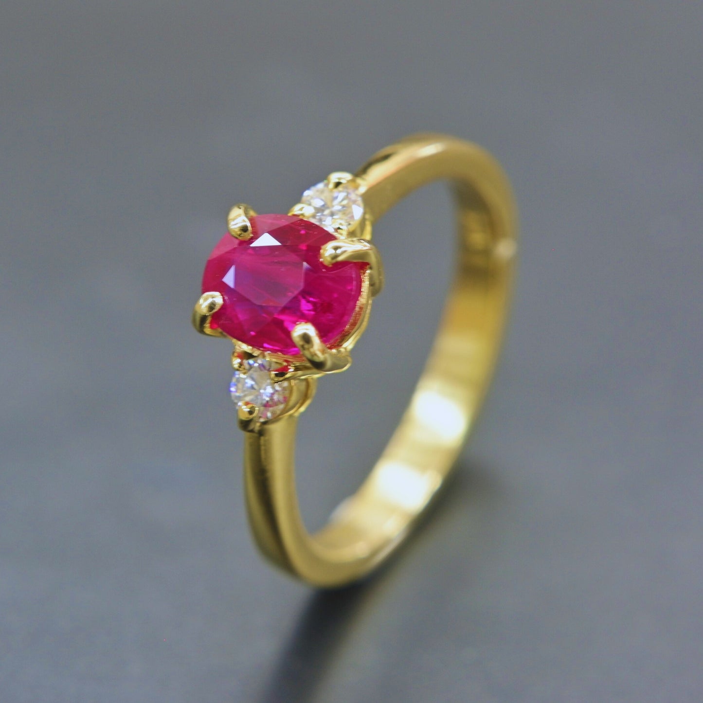 Elegant ruby ring with two diamonds in classic yellow gold setting