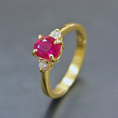Elegant ruby ring with two diamonds in classic yellow gold setting