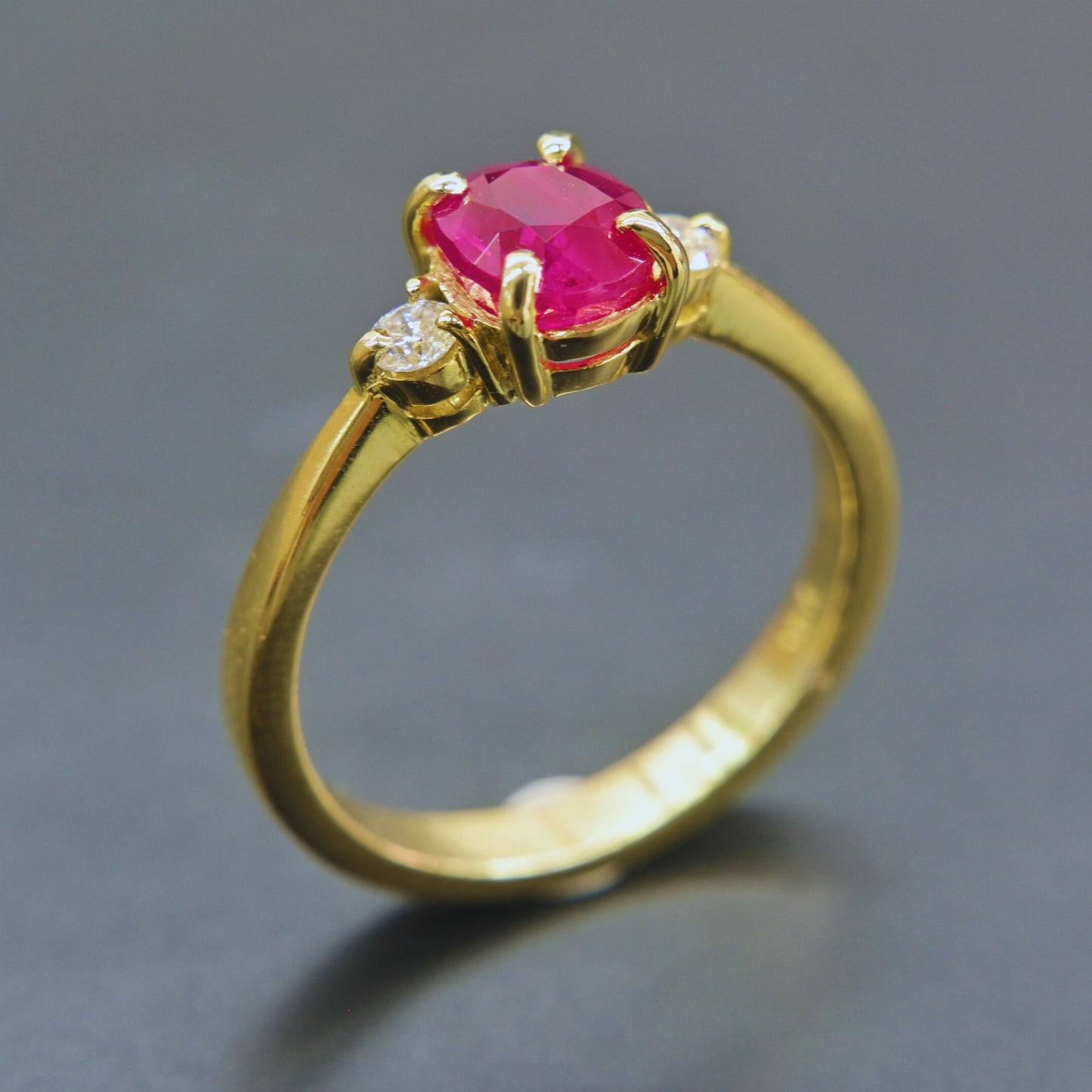 Oval ruby ring set in yellow gold with diamond accents