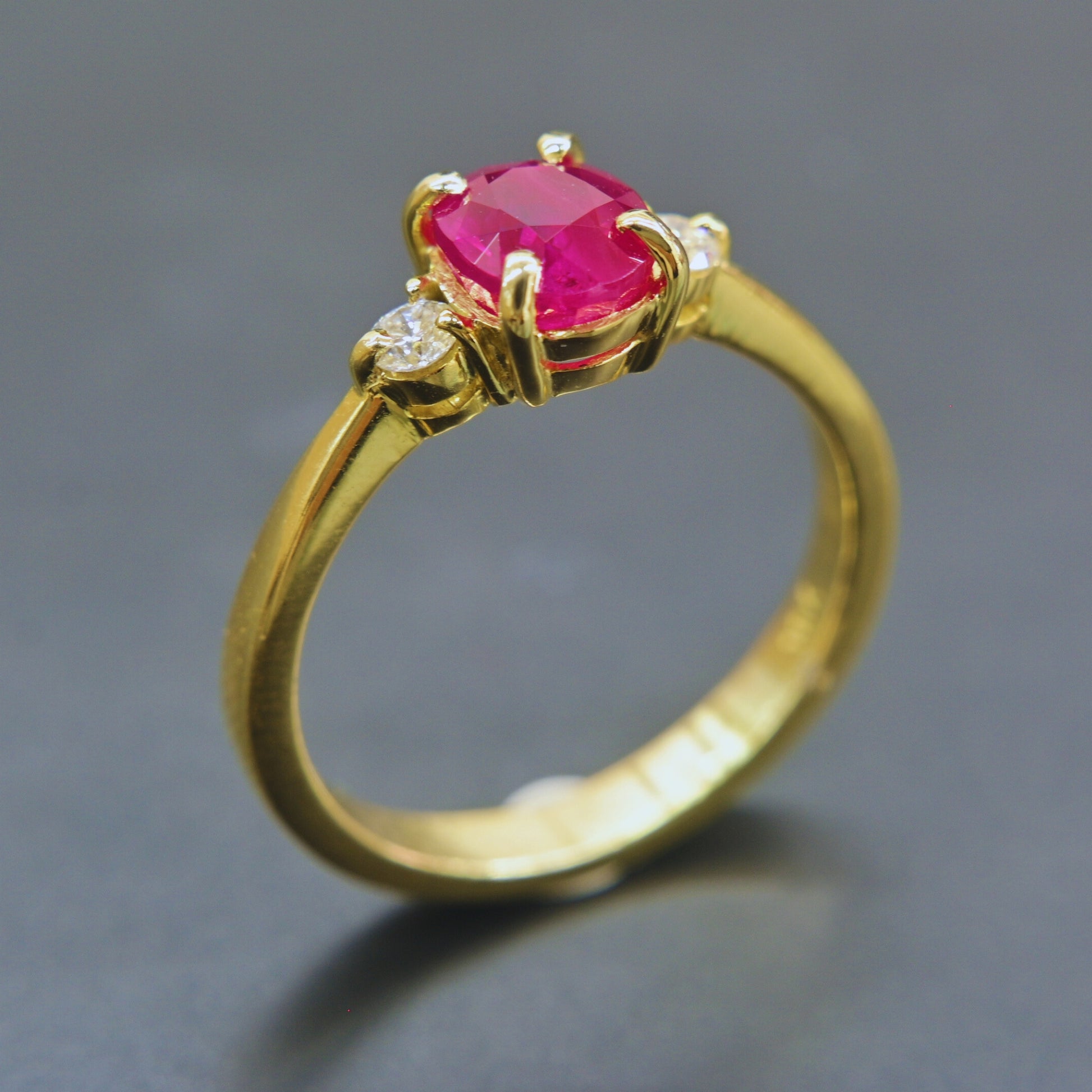 Oval ruby ring set in yellow gold with diamond accents