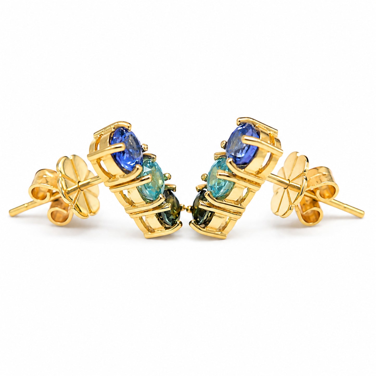A pair of gold stud earrings with a cluster of oval-cut gemstones of blue sapphire, blue zircon, and green sapphire.