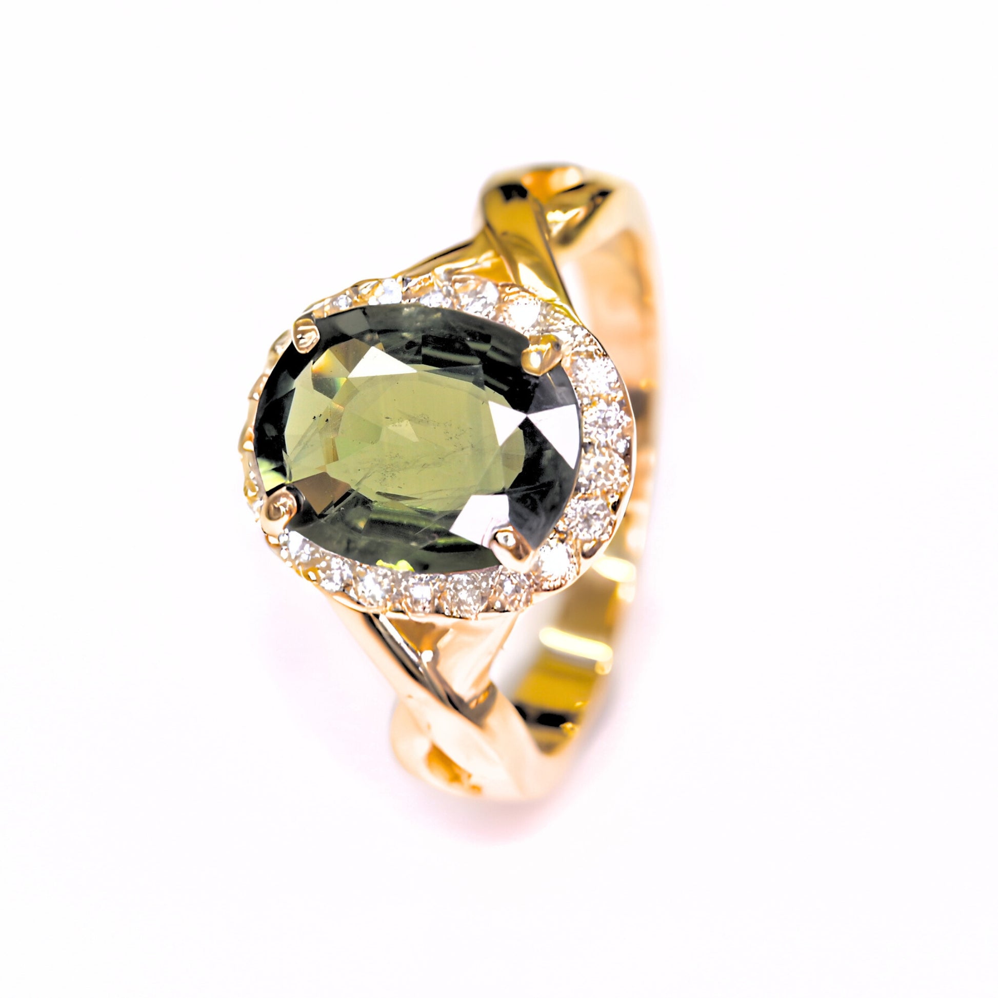Elegant green sapphire halo diamond ring in yellow gold on white background