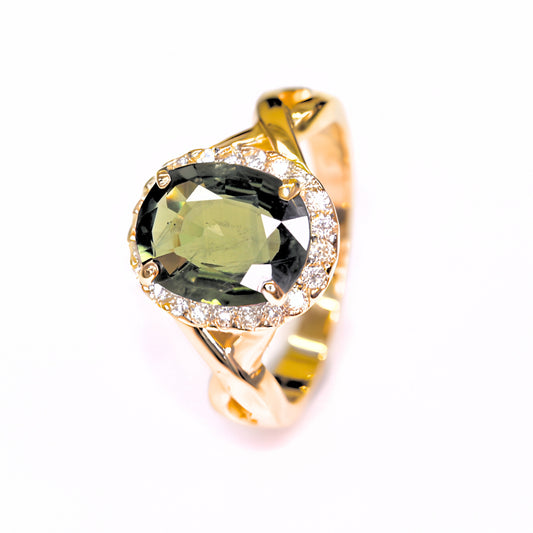 Elegant green sapphire halo diamond ring in yellow gold on white background