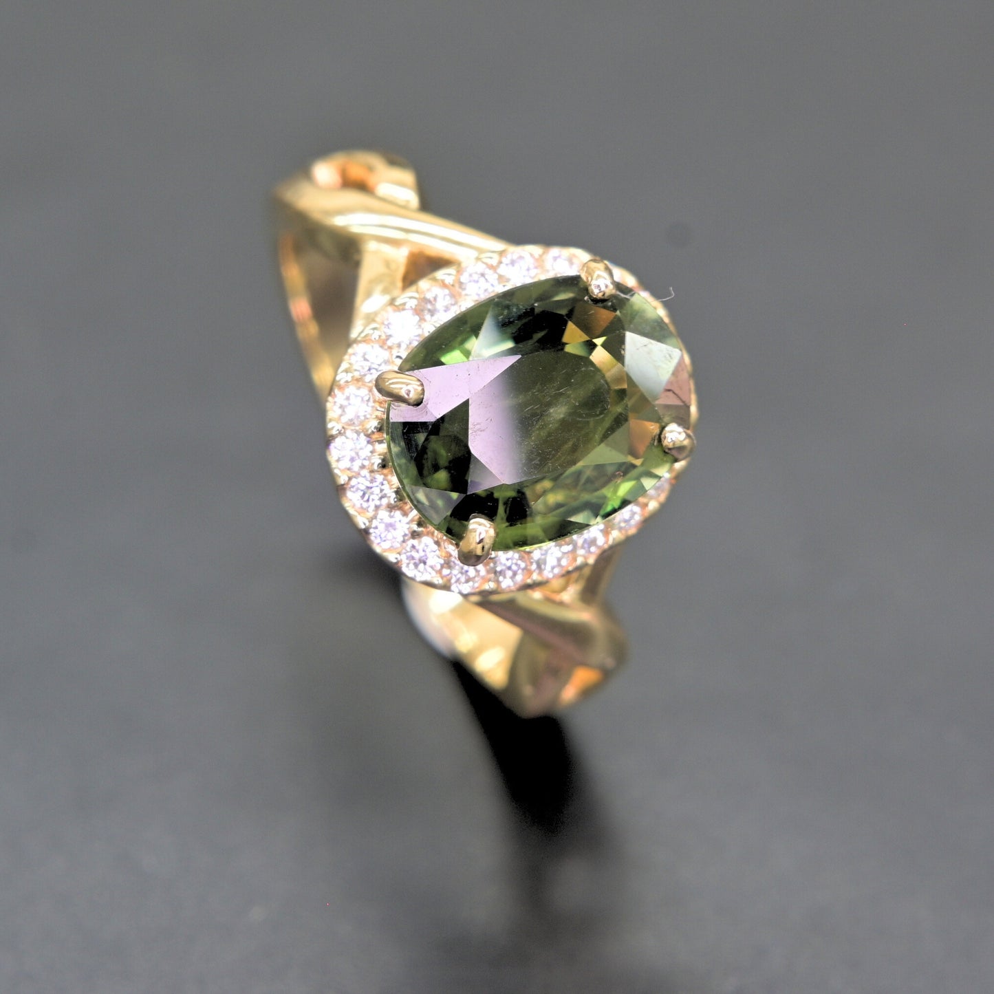 Oval green sapphire ring with diamond halo set in 14K yellow gold