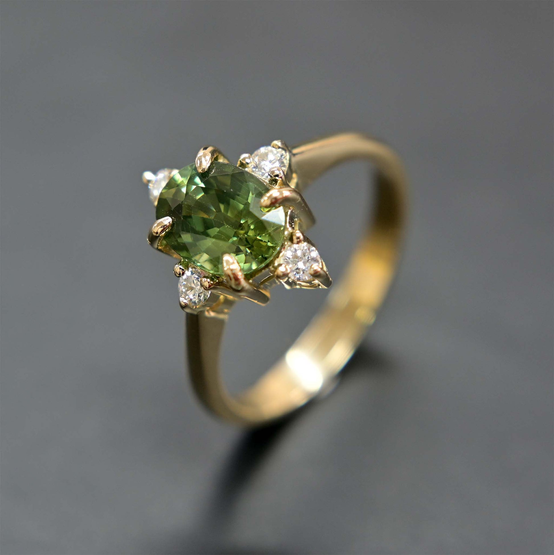 14k gold engagement ring with a beautiful green sapphire center stone and sparkling diamond accents.