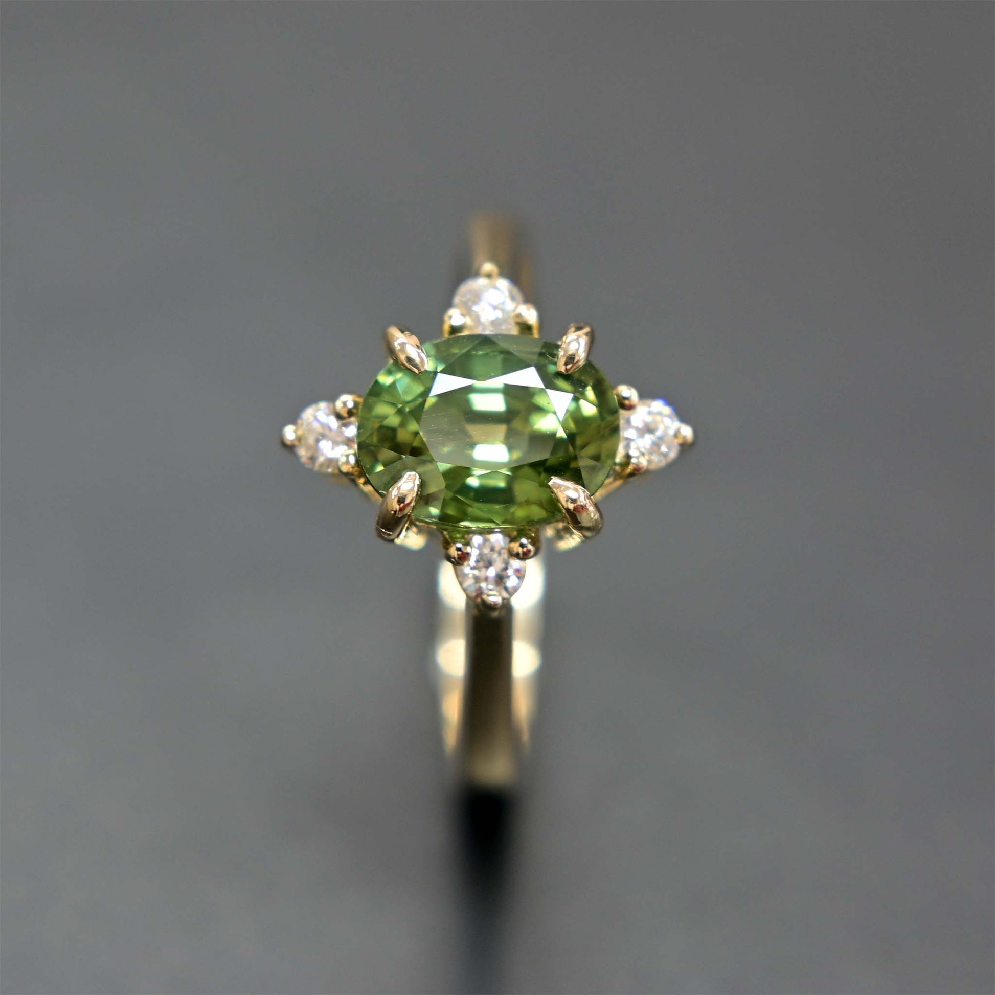 14k gold engagement ring with a beautiful green sapphire center stone and sparkling diamond accents.