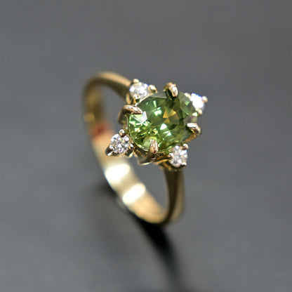 14k gold engagement ring with a beautiful green sapphire center stone and sparkling diamond accents.