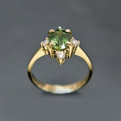 14k gold engagement ring with a beautiful green sapphire center stone and sparkling diamond accents.