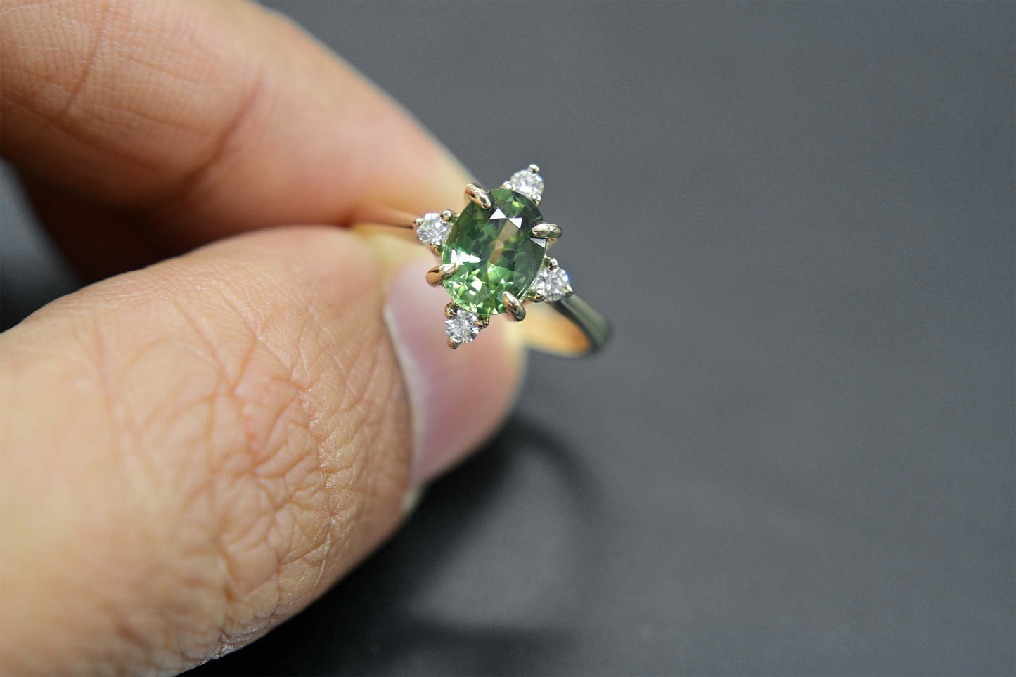 14k gold engagement ring with a beautiful green sapphire center stone and sparkling diamond accents.