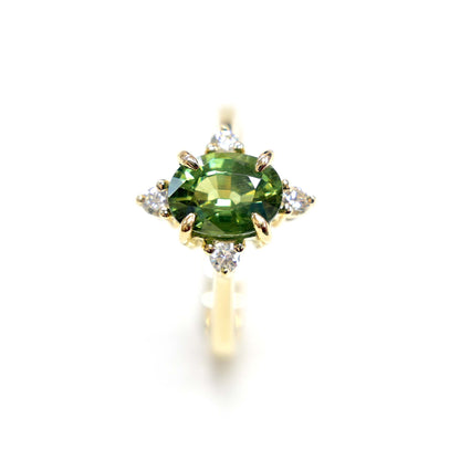 14k gold engagement ring with a beautiful green sapphire center stone and sparkling diamond accents.