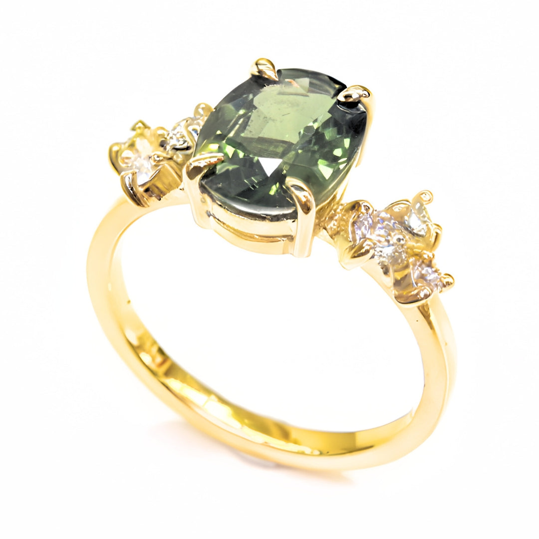 Designer gemstone ring with oval sapphire and diamonds in yellow gold band