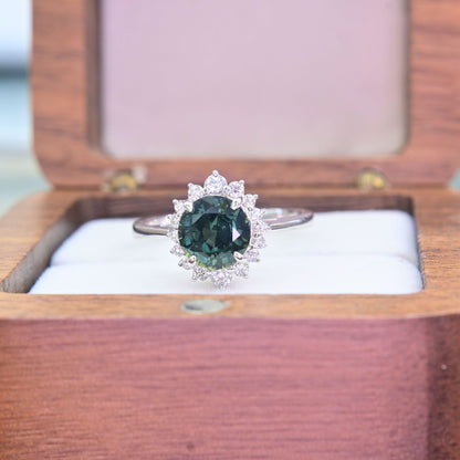 Close-up of natural green sapphire center stone surrounded by diamond halo in 18k white gold ring