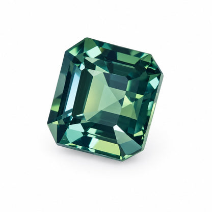 A single emerald-cut unheated teal sapphire gemstone with faceted facets, shown on a plain white background.