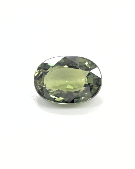Unheated 3.32 carat olive green sapphire gemstone with an oval cut.