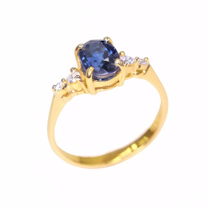Natural oval blue sapphire ring set in solid 14K yellow gold with diamond accents