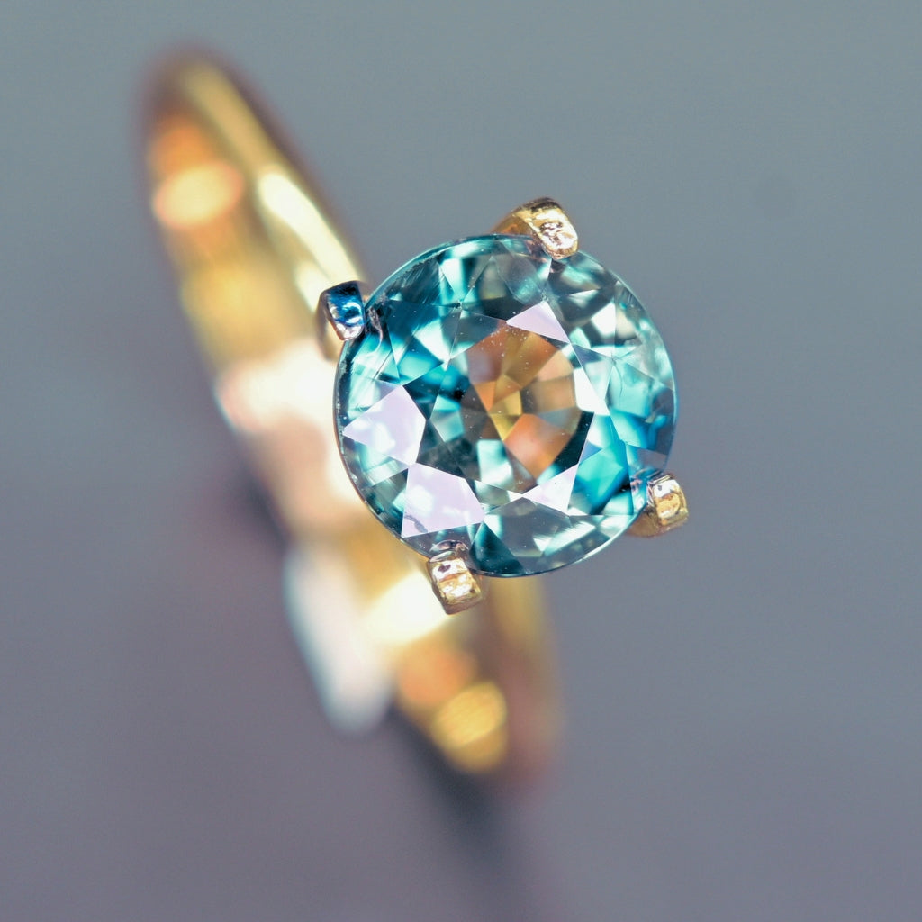 Blue-green teal sapphire displaying color shift under light