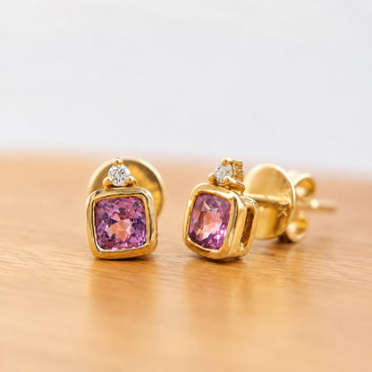 Elegant 14K gold stud earrings featuring cushion-cut pink spinels and sparkling natural diamonds.