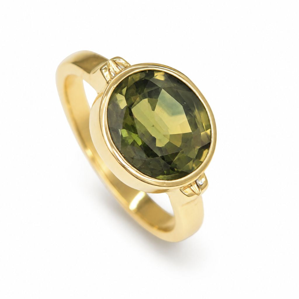 Oval 3.70 ct green sapphire engagement ring crafted in solid 14K yellow gold with a modern bezel setting and minimalist design.