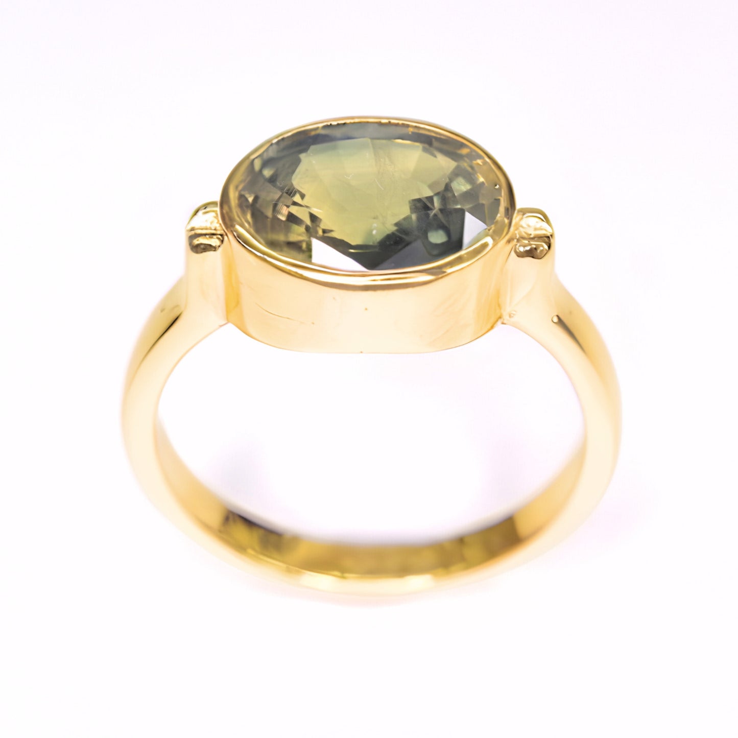 Thai green sapphire ring showing olive green and golden hues in natural light