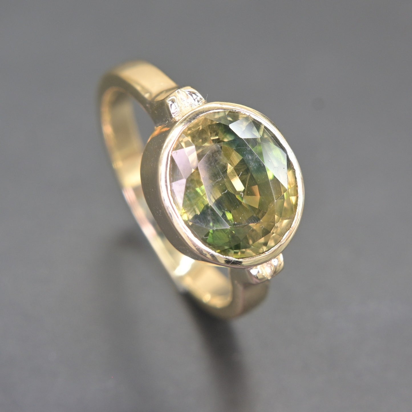 Close-up view of natural green sapphire facets in 14K gold ring