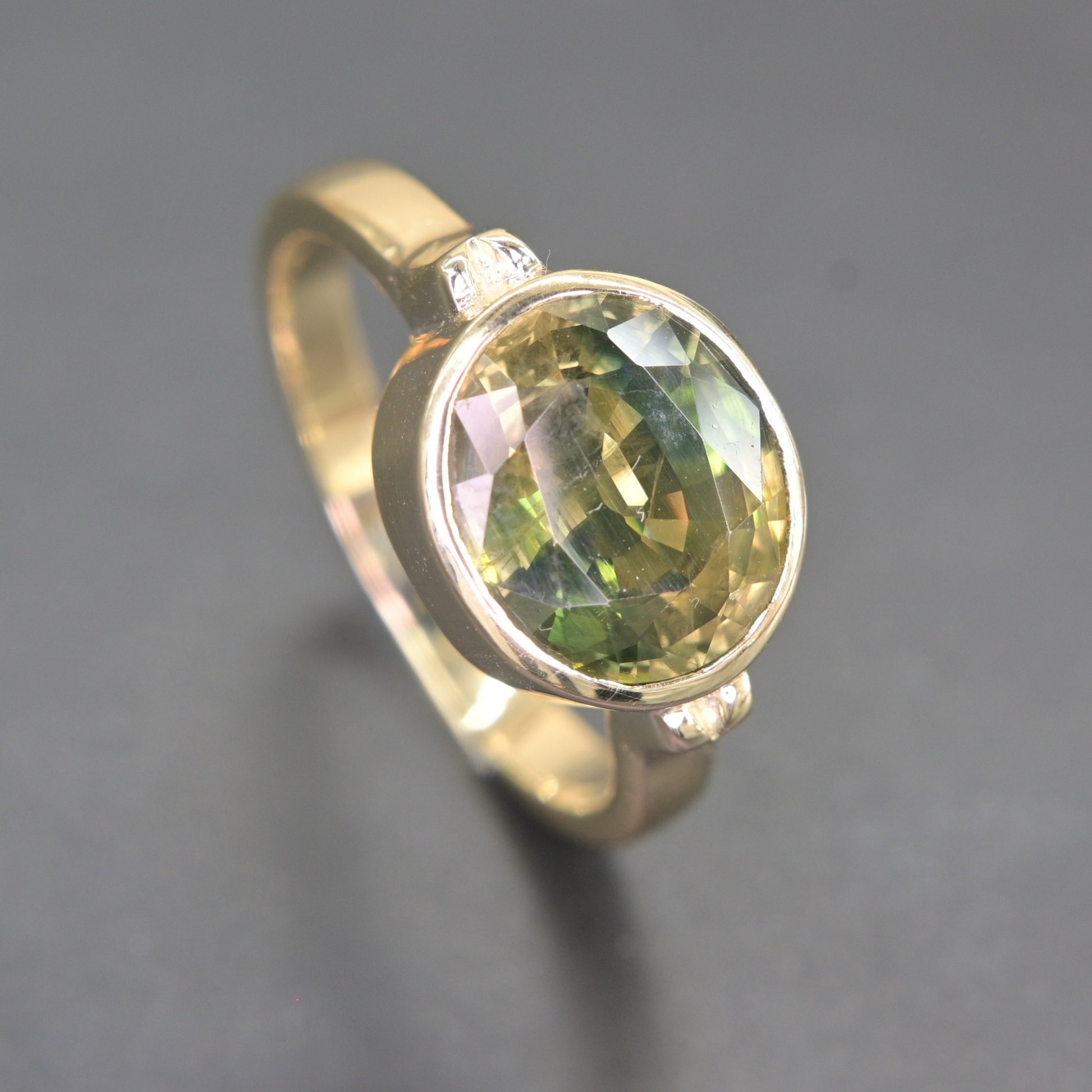 Close-up view of natural green sapphire facets in 14K gold ring