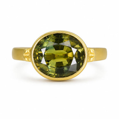 Natural Thai green sapphire ring featuring a 3.70 carat oval sapphire in a handcrafted 14K yellow gold bezel setting.
