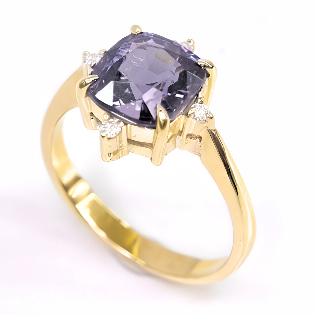 A profile shot revealing the hand-crafted 14k gold setting and the unique four-prong design holding the spinel, with the delicate diamond accents on each side.