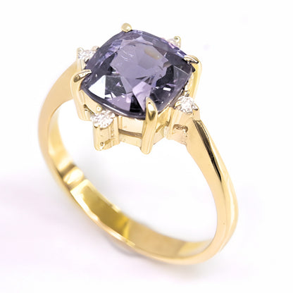 A profile shot revealing the hand-crafted 14k gold setting and the unique four-prong design holding the spinel, with the delicate diamond accents on each side.