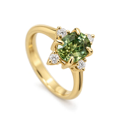 The Sofia oval green sapphire engagement ring with four sparkling diamonds and gold prongs