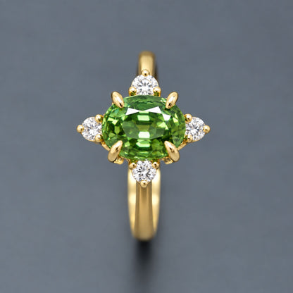 Thai green sapphire engagement ring featuring a vivid faceted green center sapphire and diamond cluster