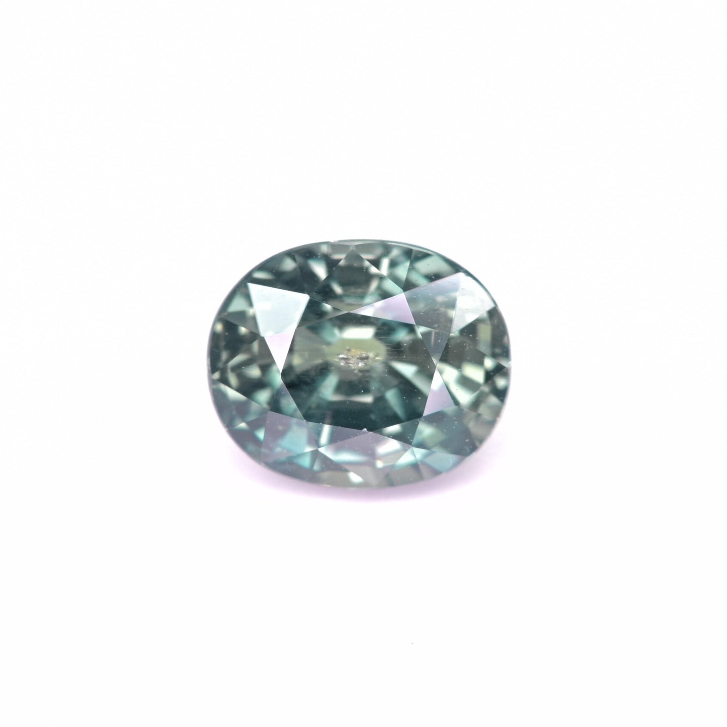 Unheated teal sapphire 4.02 carat oval cut loose gemstone on white background