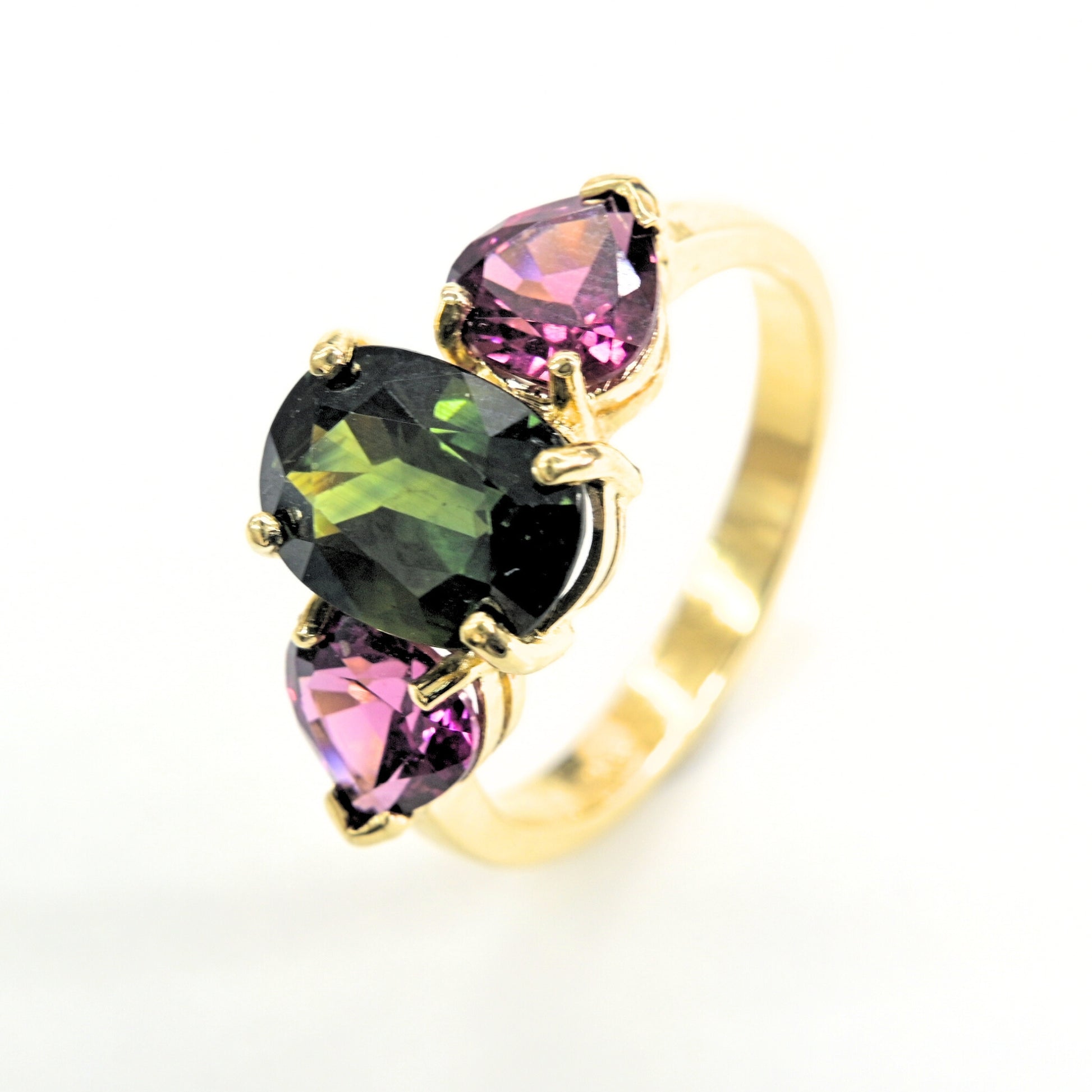 18K gold ring featuring a natural green sapphire with rhodolite side stones