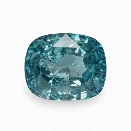 2.13 carat unheated cushion cut teal sapphire displaying rich ocean blue-green color and natural internal inclusions on a white background