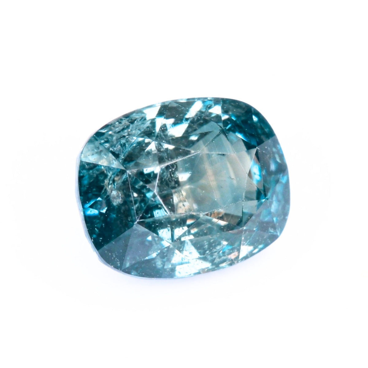 Top-down macro view of a 2.13ct natural unheated teal sapphire showing cushion brilliant faceting and authentic character