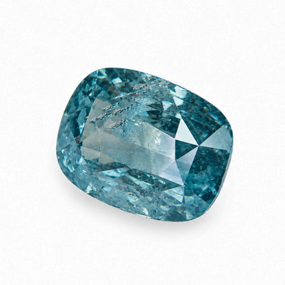 Loose 2.13 carat unheated blue-green teal sapphire held in jeweler tweezers under neutral laboratory lighting.