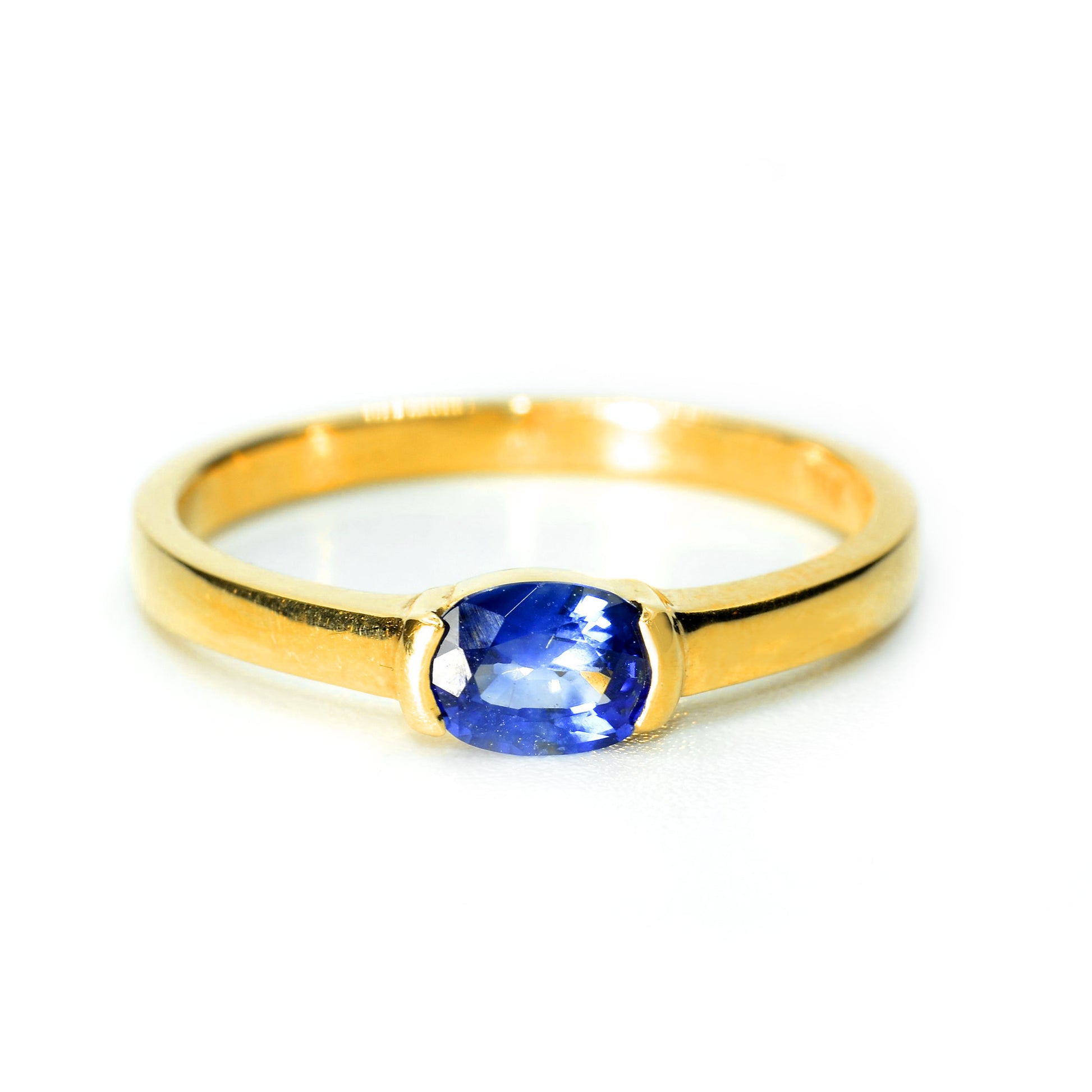 Front view of Half bezel blue sapphire ring in 18K yellow gold setting. Handmade by Shiraz Jewelry in Chiang Mai