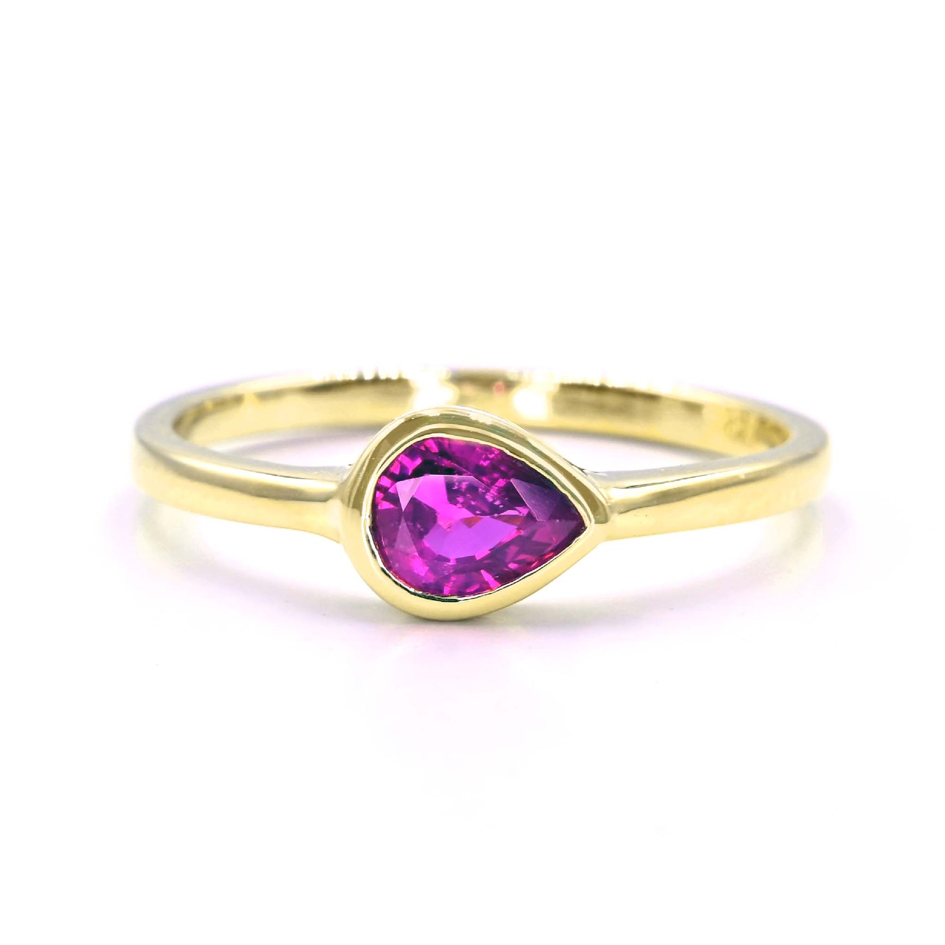 Teardrop ruby solitaire ring set in polished 14K gold band