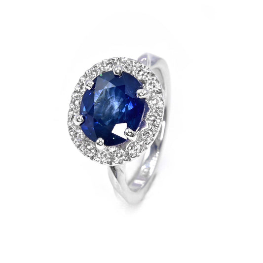Handmade 18K white gold engagement ring with large blue sapphire and diamond halo by Shiraz Jewelry