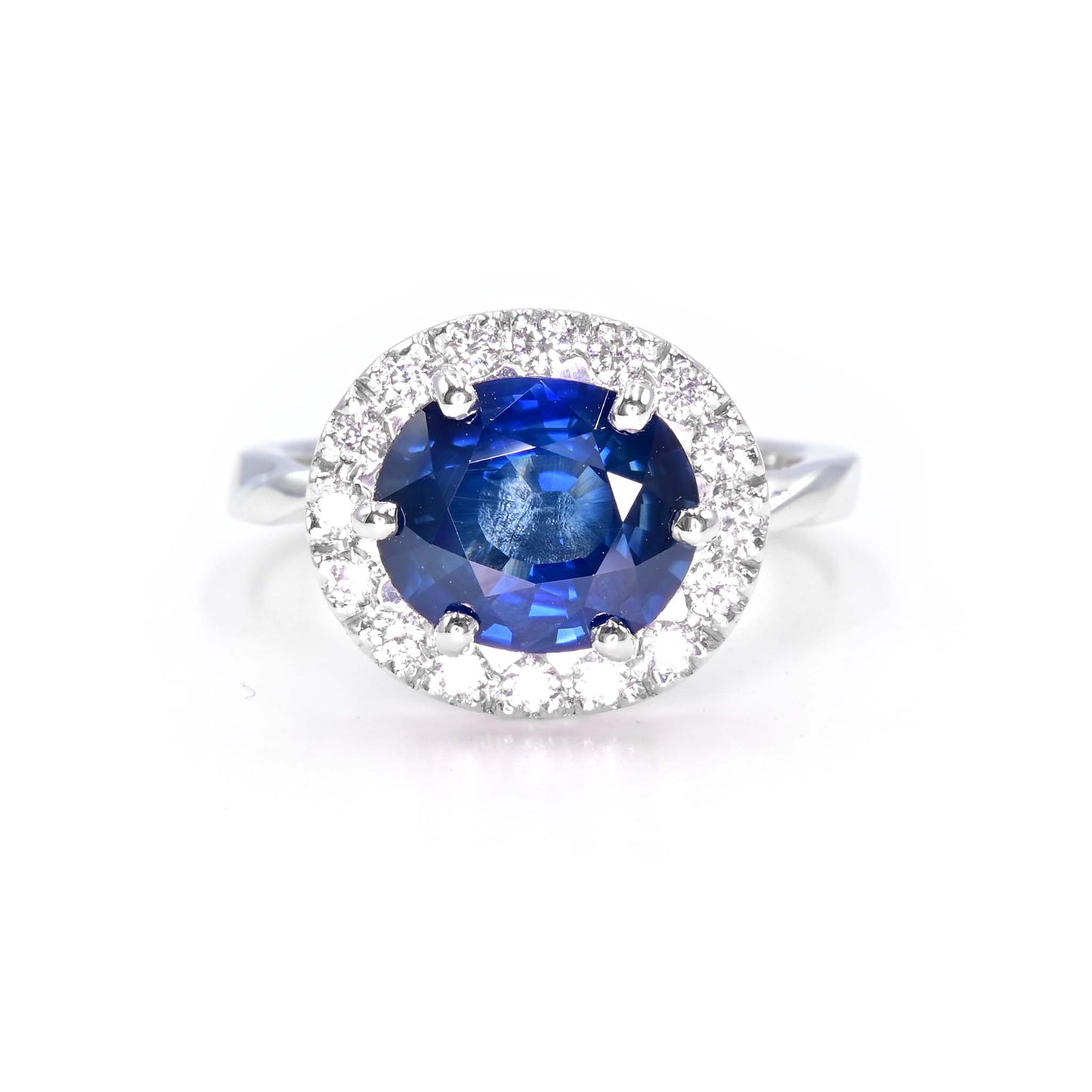 Natural blue sapphire ring with diamond halo setting in 18K white gold, handcrafted in Chiang Mai
