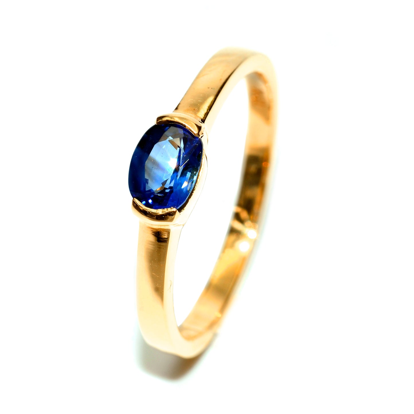 Half bezel blue sapphire ring in 18K yellow gold setting. Handmade by Shiraz Jewelry in Chiang Mai